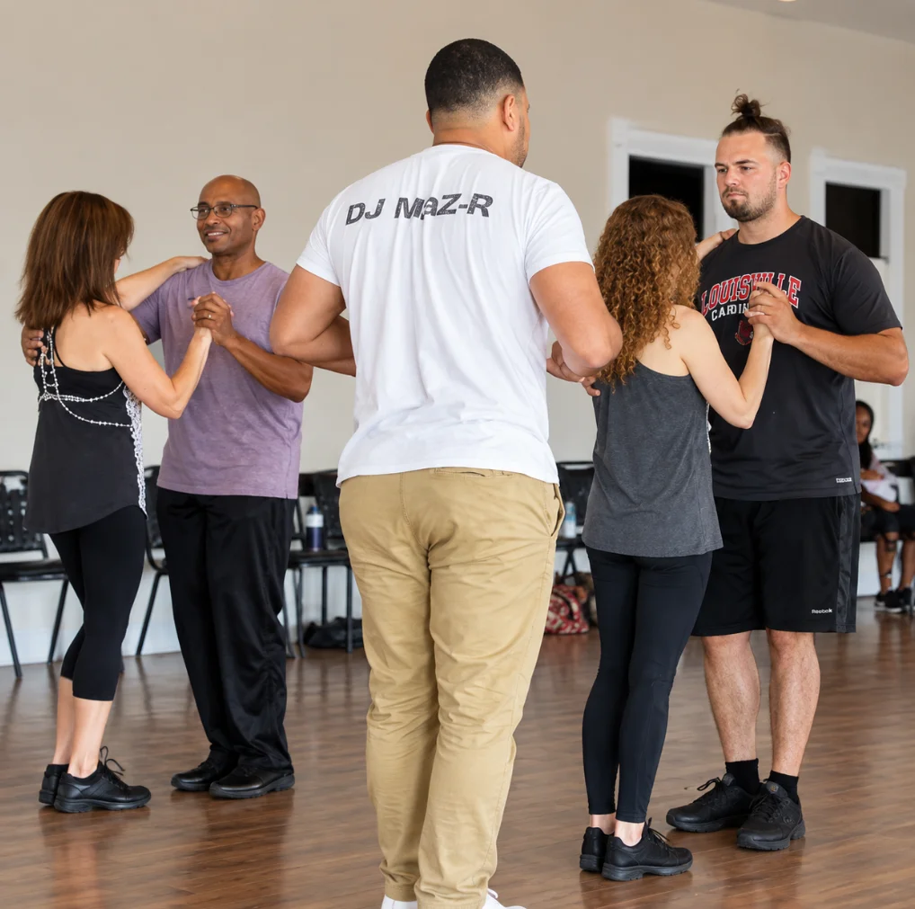 An instructor guiding two couples through a partner dance lesson.