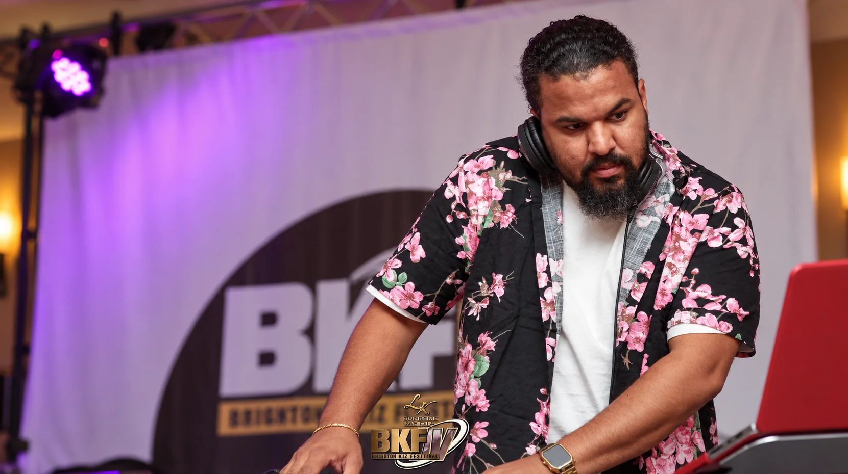 DJ MaZ-R wearing headphones at his DJ equipment during an event.